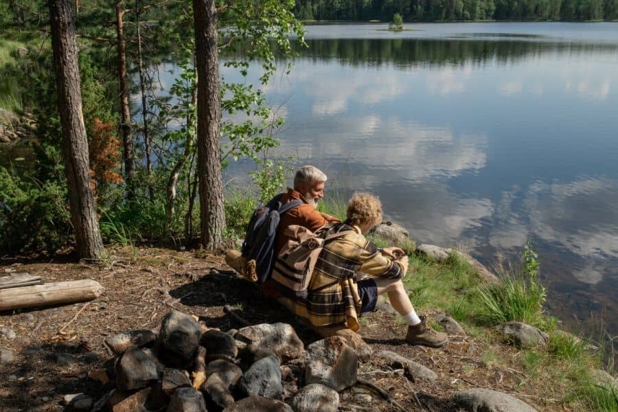 Dva turisté sedící u jezera
