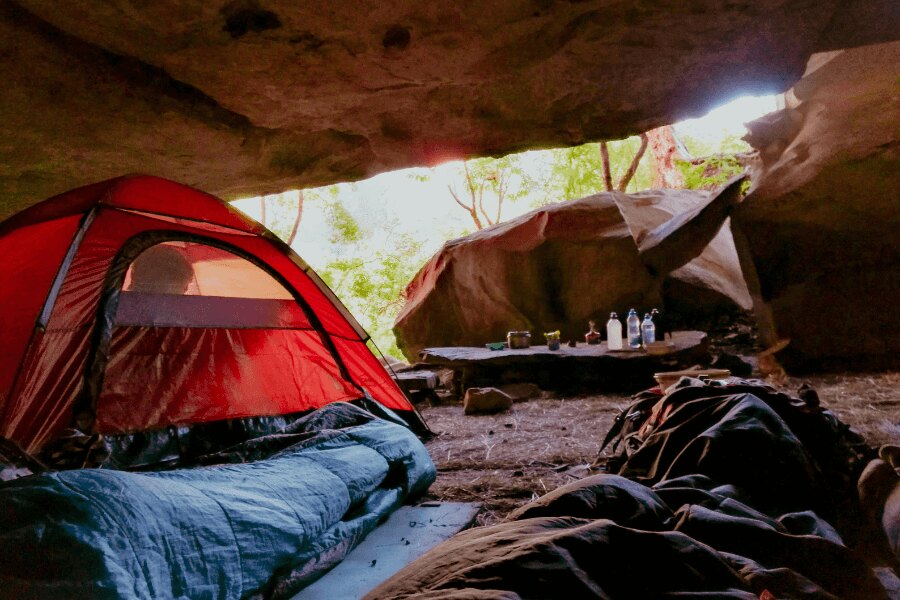 Spacák a stan pod skalním převisem. Zdroj: https://www.pexels.com/cs-cz/foto/svetly-lehky-krajina-priroda-2412023/