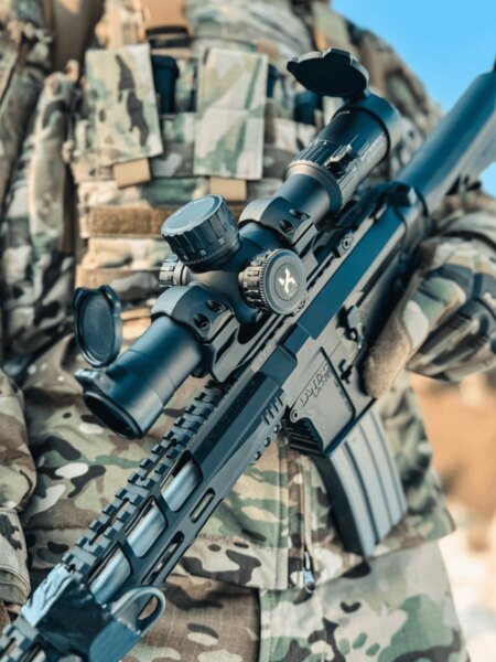 Puškohled Vortex Optics detailně na moderní útočné pušce s montáží na liště Picatinny, střelec v maskáčích. Foto: Rigad
