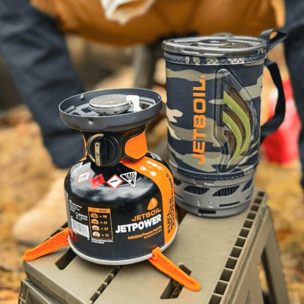 Vařič Jetboil s kartuší Jetpower a izolačním hrncem na podkladu. Foto: Rigad