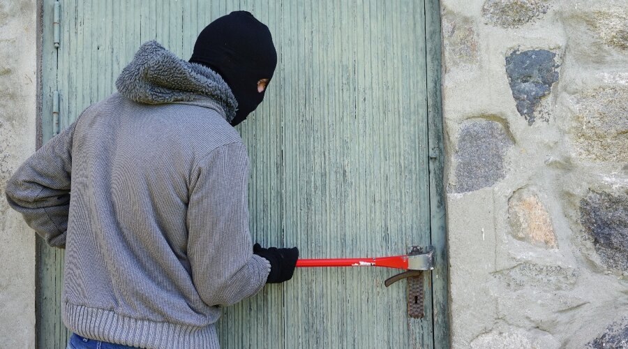 Muž se páčidlem dostává do domu