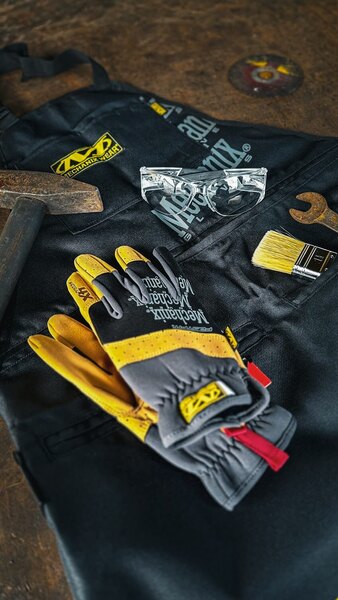 Pracovní rukavice Mechanix Wear na dílenském stole – odolné rukavice vhodné pro zimní manipulaci s řetězy, vyprošťování auta a práci v mrazu. Foto: Rigad