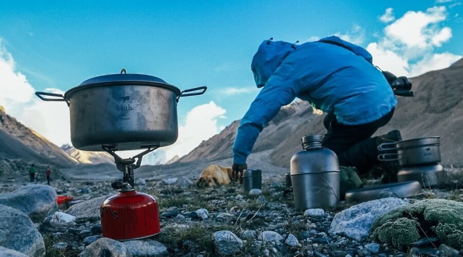 Muž vaří v outdoorovém nádobí