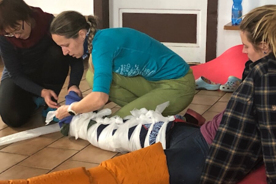 Žena fixuje figurantce nohy různými způsoby