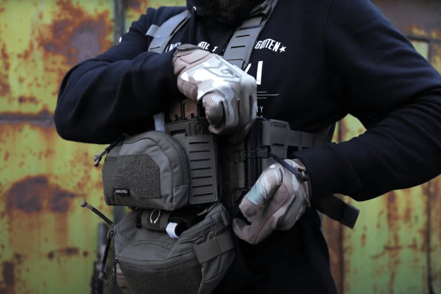 Muž s Chest Rig Reaper™ Agilite Gear® osazeným sumkama upravuje nastavení. Zdroj: Rigad - video