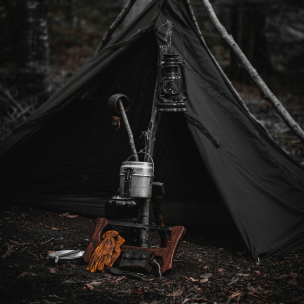 Bushcraftový přístřešek v lese. Zdroj: https://www.pexels.com/cs-cz/foto/les-dobrodruzstvi-kempovani-lampion-14074699/