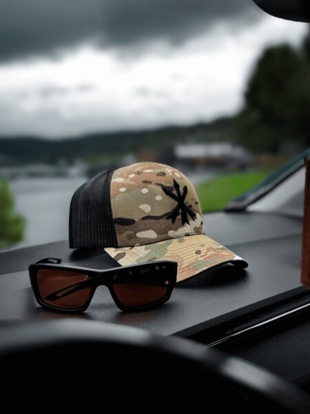 Multicam trucker kšiltovka s logem Unity Tactical a střelecké ochranné brýle na palubní desce. Foto: Rigad