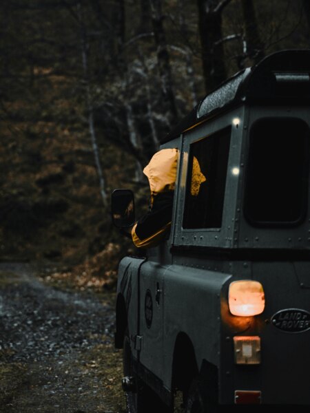Terénní automobil projíždí lesní cestou za šera, zvýšené riziko střetu se zvěří. Zdroj: https://www.pexels.com/cs-cz/foto/osoba-les-vozidlo-rizeni-9258033/
