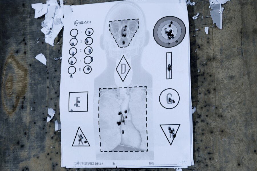 Terč Best Basics Type A2 s anatomickým podkresem, zásahovými zónami a tréninkovými obrazci po střelbě. Foto: Rigad