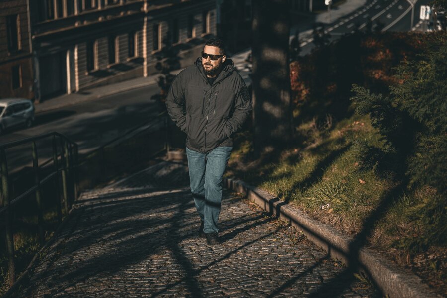 Muž v zimní bundě Yukon Climashield Apex Helikon-Tex při chůzi městem. Foto: Rigad