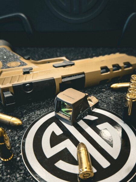 Kolimátor SIG Sauer ROMEO-X pro pistole položený před pistolí SIG Sauer a střelivem 9 mm. Foto: Rigad