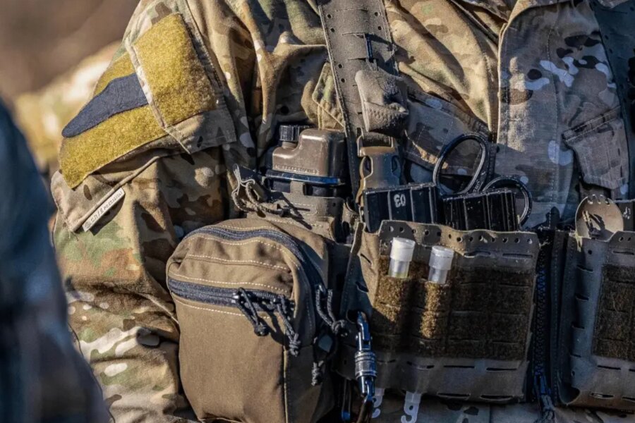 Detail taktické výstroje s hydratační lahví Qore Performance ICEFLASK® umístěnou v nosiči plátů.
