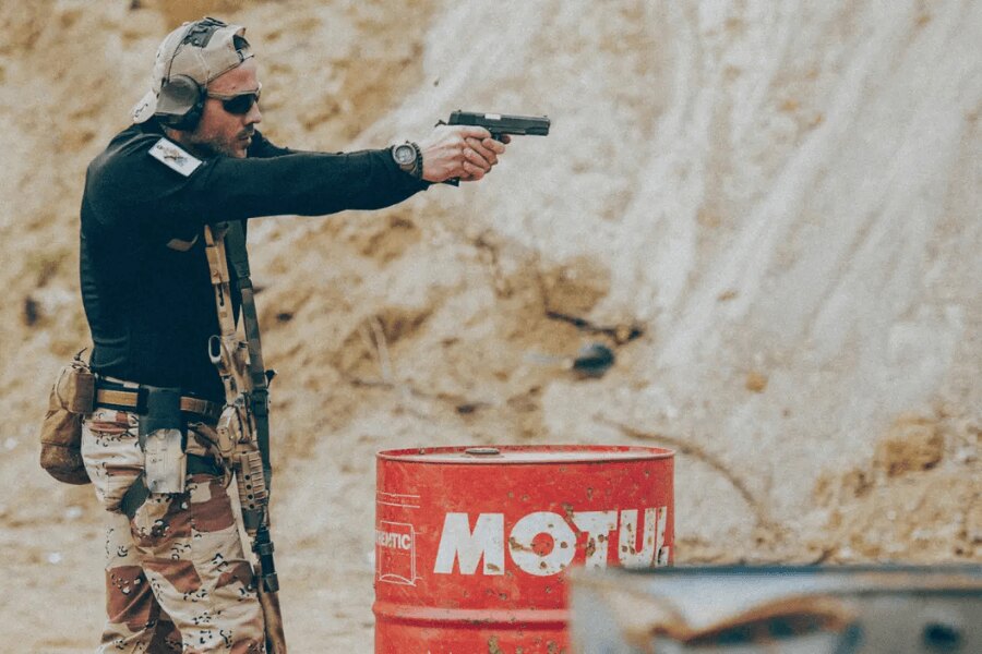 Střelec s pistolí a výstrojí při dynamické střelbě na střelnici