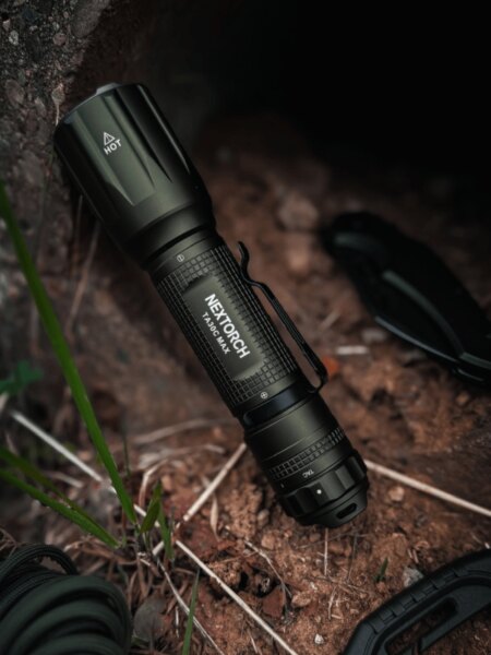 Kompaktní svítilna Nextorch TA30C MAX položená na zemi v outdoorovém prostředí.