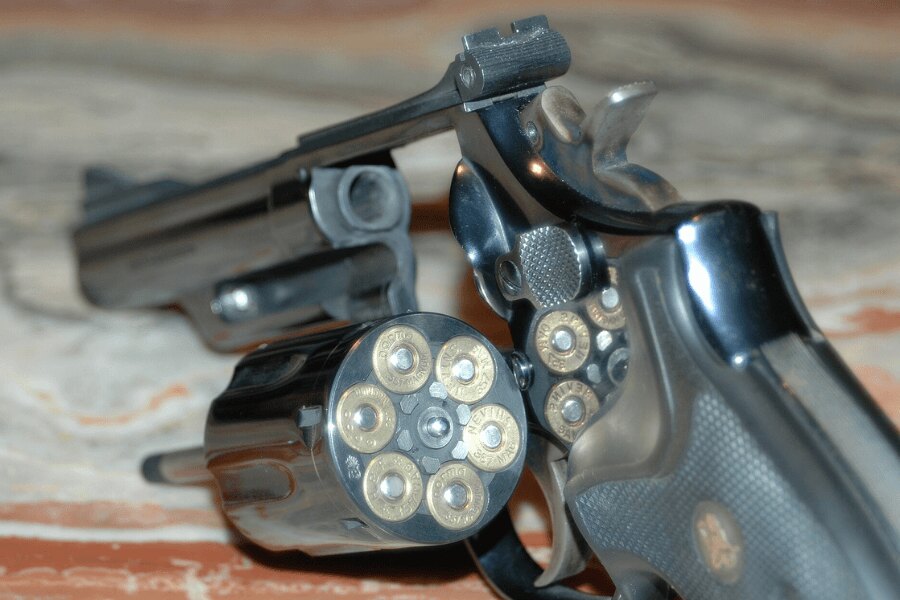 Revolver Smith & Wesson Model 19 s otevřeným válcem a náboji .357 Magnum.
