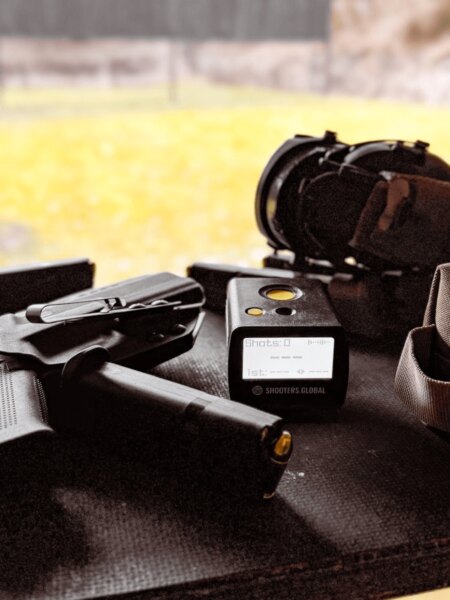 Pistole, zásobníky, střelecký timer Shooters Global a ochranná sluchátka připravené k tréninku.