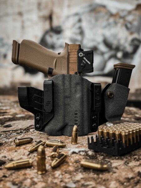 Pistole s kolimátorem Aimpoint uložená v pouzdře Safariland Incog X s náhradním zásobníkem.