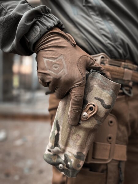Uvolňování retenčního mechanismu pouzdra Safariland v provedení MultiCam před tasením pistole.