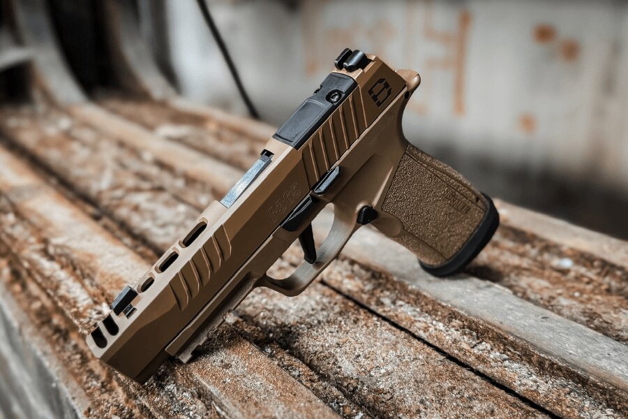 Pistole SIG Sauer P365 s mechanickou muškou a hledím položená na dřevěném stole.