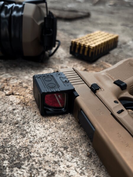 Detail uzavřeného kolimátoru Holosun namontovaného na pistoli Glock 19X.
