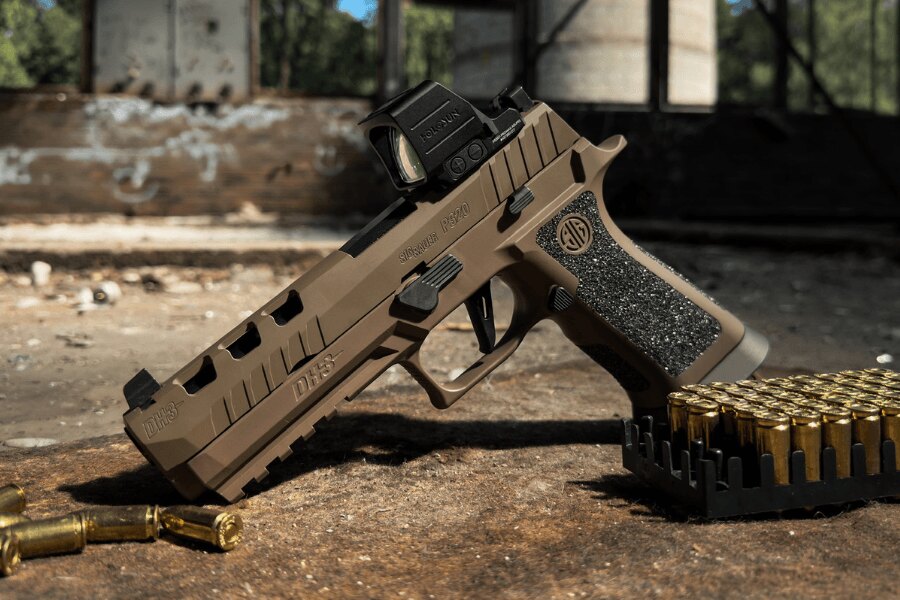 Pistole SIG Sauer P320 DH3 s kolimátorem Holosun položená vedle střeliva.