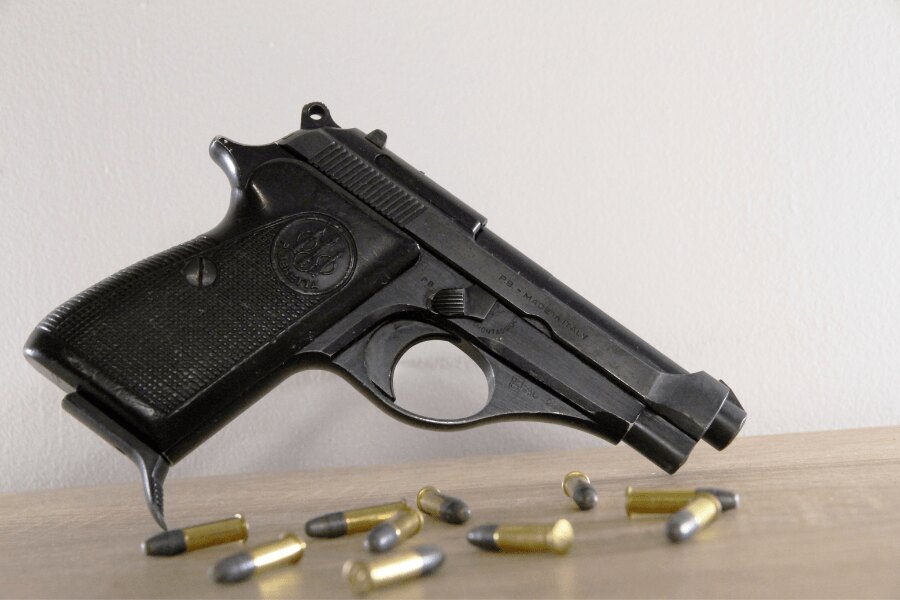 Boční pohled na pistoli Beretta 71 s náboji ráže .22 LR.