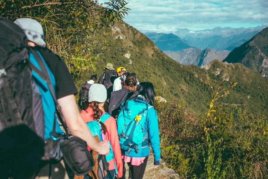 Skupina turistů chodící horami