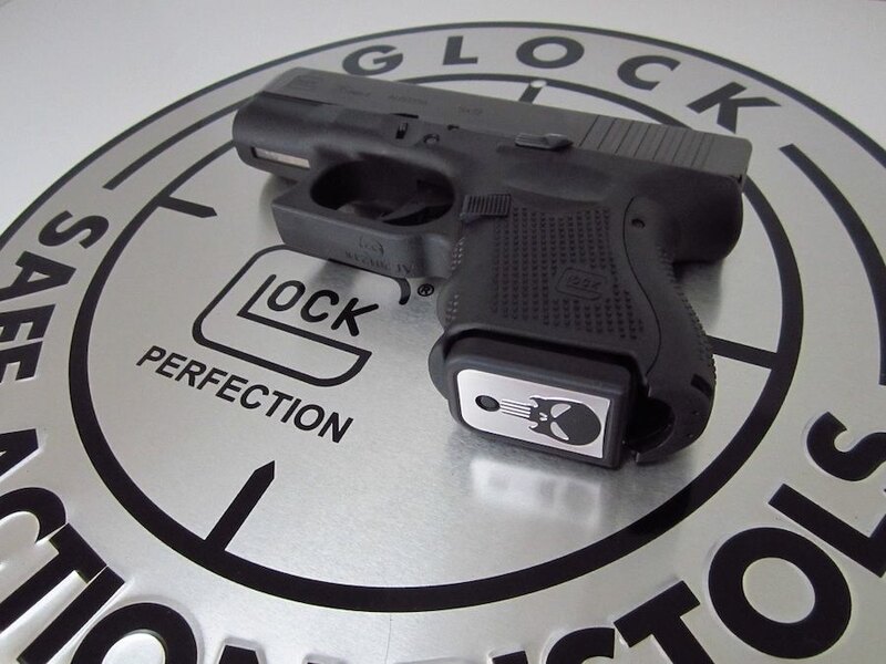 Pistol Glock položená na stříbrném podkladu
