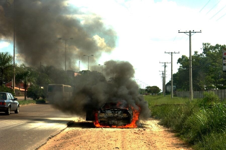 Hořící auto u silnice