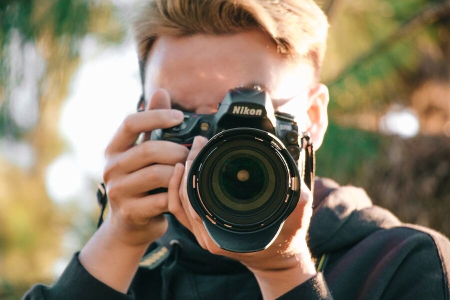Muž fotící s fotoaparátem Nikon