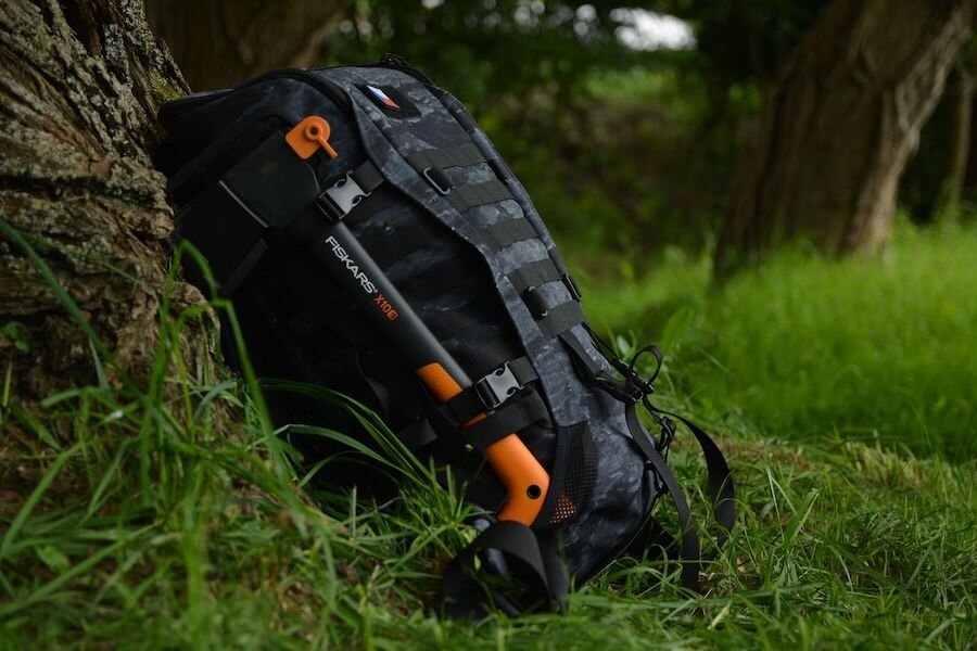 Sekera Fiskars X10 připevněná na batohu