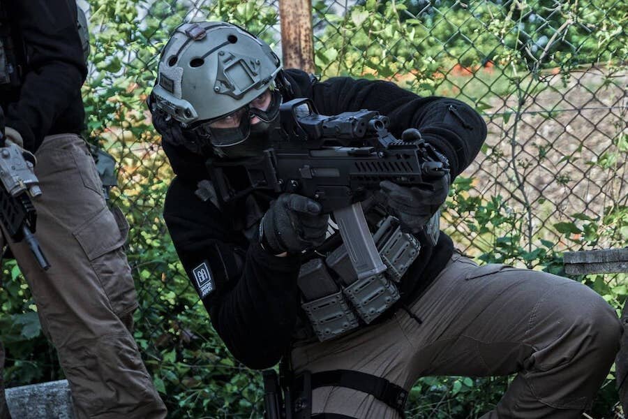 Hráč airsoftu mířící zbraní